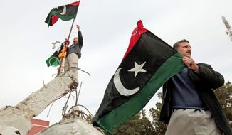 Libyans wave the country&#39;s monarchist-era flag Monday on a monument in the southwestern town of Nalut. The town is now under the control of Libyan anti-government forces. The protesters hope to take control of the entire country without outside intervention. (Associated Press)