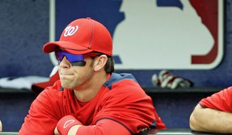 Washington Nationals&#39; Bryce Harper watches from the dugout Monday at the start of a spring-training baseball game against the New York Mets in Port St. Lucie, Fla. The 18-year-old outfielder got into the game but struck out twice in two at-bats against major league pitching. (Associated Press)