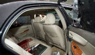A Pakistani man examines the blood-stained car of Shahbaz Bhatti, minister for minorities affairs and the only Christian in the Cabinet, on Wednesday in Islamabad. Mr. Bhatti was fatally shot in the car near his mother&#39;s house. (Associated Press)