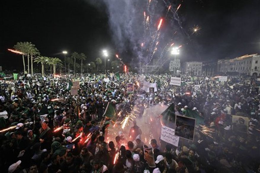Pro-Gadhafi supporters set off fireworks at an organised rally in Green Square, Tripoli, Libya Friday, March 4, 2011. In Tripoli, Gadhafi loyalists fired tear gas and live ammunition to smother a new outbreak of protests, while thousands of Gadhafi supporters later packed into the capital's central Green Square, waving green flags and pictures of the Libyan leader in a counterdemonstration complete with fireworks. (AP Photo/Ben Curtis)