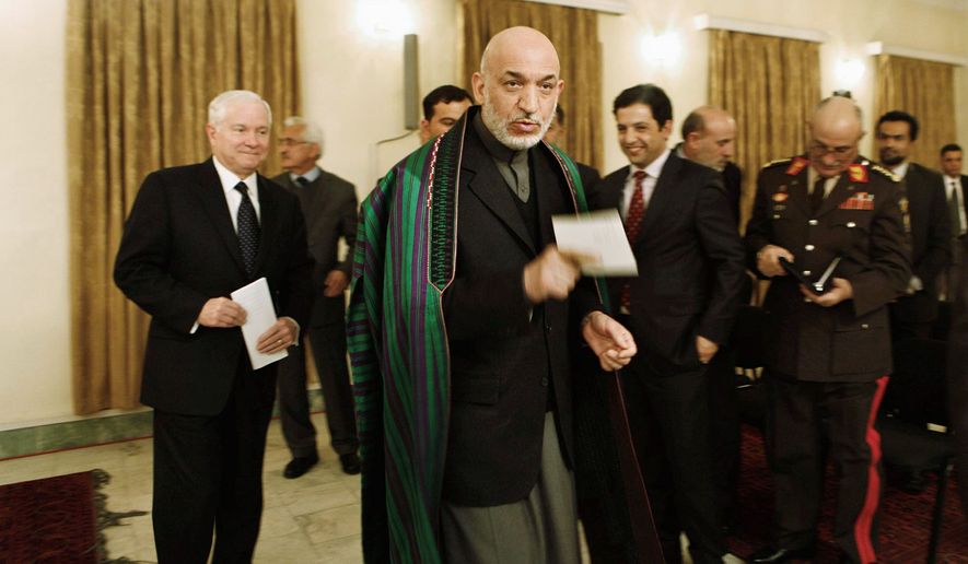 STAYING?: Secretary of Defense Robert M. Gates (left) and Afghan President Hamid Karzai discussed a pullout date for U.S. troops on Monday. Mr. Gates said some forces could stay after the 2014 pullout goal. (Associated Press)
