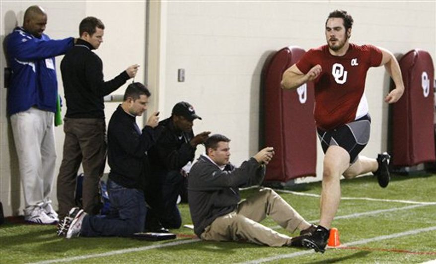 Joe Greene, center, of the Pittsburgh Steelers, and Jack Glowik, right, of the Baltimore Ravens, time players in the 40-yard dash at Oklahoma Pro Day for NFL scouts in Norman, Okla., Tuesday, March 8, 2011. (AP Photo/Sue Ogrocki)