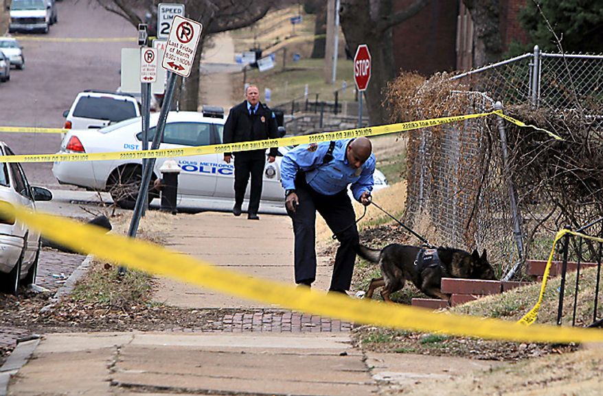 St. Louis police search for a gunman Tuesday, March 8, 2011, in St. Louis. Police say two federal marshals and a police officer have been shot during a gunfight that left another man wounded at a home. (AP Photo/St. Louis Post-Dispatch, Christian Gooden)