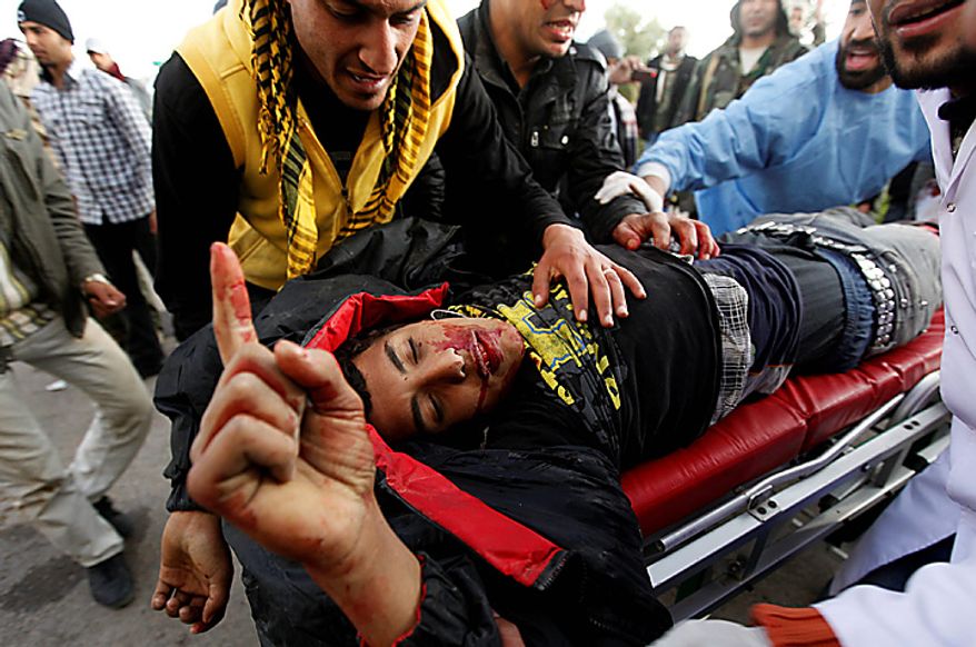 An injured anti-Moammar Gadhafi rebel, who was wounded during the fighting against pro-Gadhafi fighters, is wheeled into a hospital in the town of Ras Lanouf, eastern Libya, Wednesday, March 9, 2011. A high-ranking member of the Libyan military flew to Cairo on Wednesday with a message for Egyptian army officials from Moammar Gadhafi, whose troops pounded opposition forces with artillery barrages and gunfire in at least two major cities. (AP Photo/Hussein Malla)