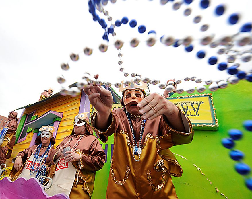 Maskers with the Knight of Revelry tosses beads to the crowds gathered on Government Street in Mobile, Ala., Tuesday, March 8, 2011, for the pre-Lenten blowout along the Gulf Coast called Fat Tuesday. (AP Photo/Press-Register, John David Mercer)