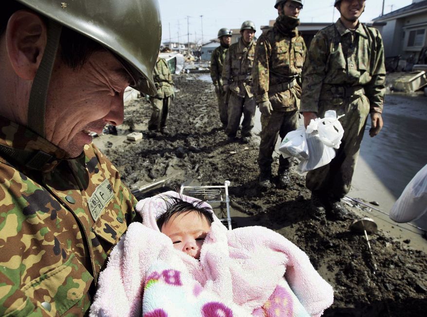 SURVIVOR: A 4-month-old girl was found alive in Ishinomaki on Monday. The baby's parents, who were holed up in their home for three days, had handed the child to soldiers. (Yomiuri Shimbun via Associated Press)