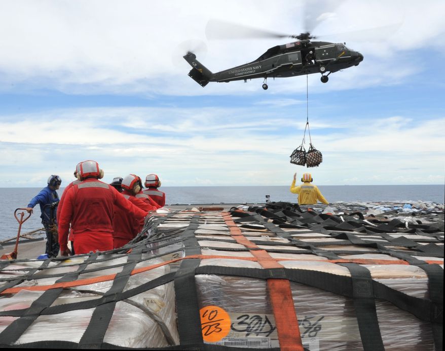 Sailors aboard the U.S. 7th Fleet command ship USS Blue Ridge (LCC 19) in the South China Sea stand by to move pallets of humanitarian relief supplies across the ship's flight deck to replenish the USNS Rappahannock. The Blue Ridge is ensuring the crew of the Rappahannock is ready if directed to assist with earthquake and tsunami relief operations in Japan. (AP Photo/U.S. Navy, Mass Communication Spec. 3rd Class Fidel C. Hart)