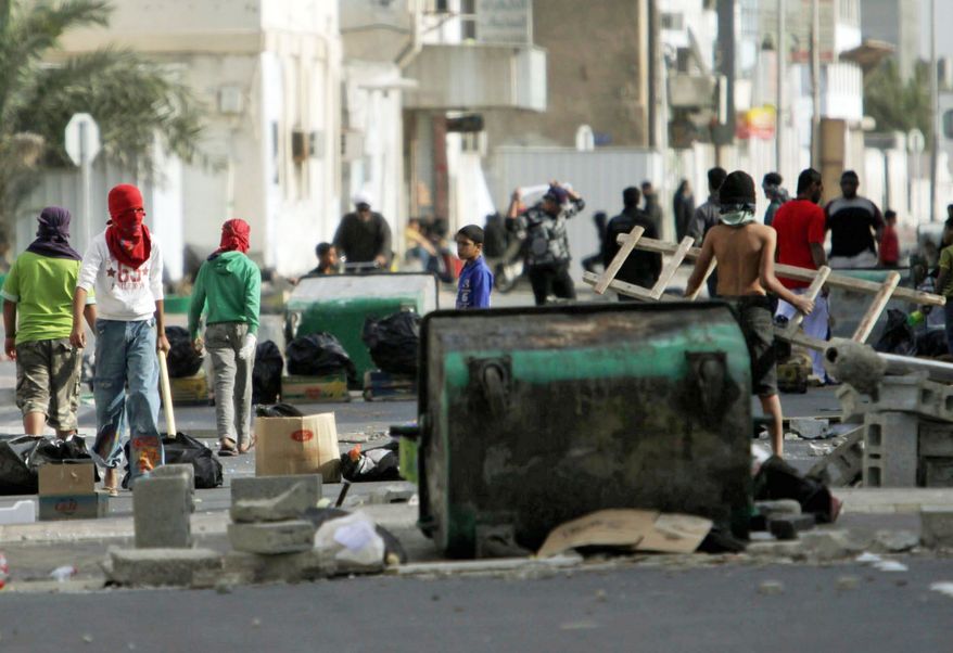 Shiite Bahraini youths haul debris into the streets of the western village of Malkiya on Wednesday in preparation for government-supporting forces they expect will roll into their Shiite Muslim village southwest of the capital of Manama. (Associated Press)