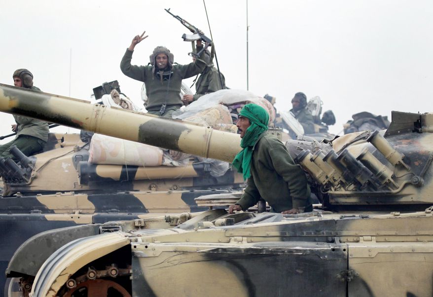 Libyan soldiers loyal to Moammar Gadhafi's regime pause at the western entrance to Ajdabiya. (Associated Press)