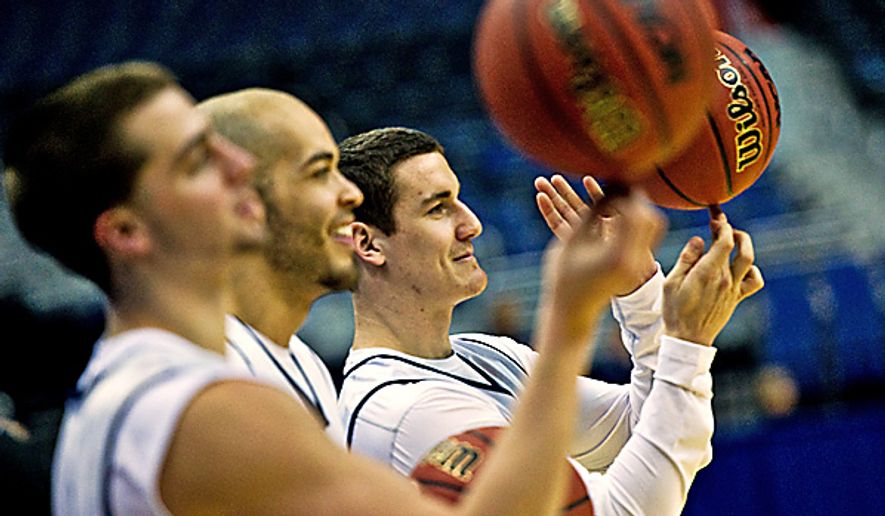 Far right, University of Connecticut player P.J. Cochrane spins the ball during open practice at the Verizon Center, in Washington, Wednesday, March 16, 2011. (Drew Angerer/The Washington Times)