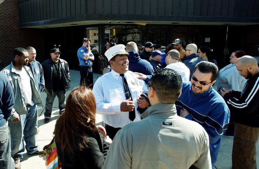 Camden, N.J., Fire Chief Mike Harper celebrates with police officers and firefighters outside the Camden Police Administration building Thursday after Mayor Dana Redd announced the city will rehire 50 of the police officers and 15 firefighters laid off earlier this year amid a budget crisis in the city. (Associated Press)