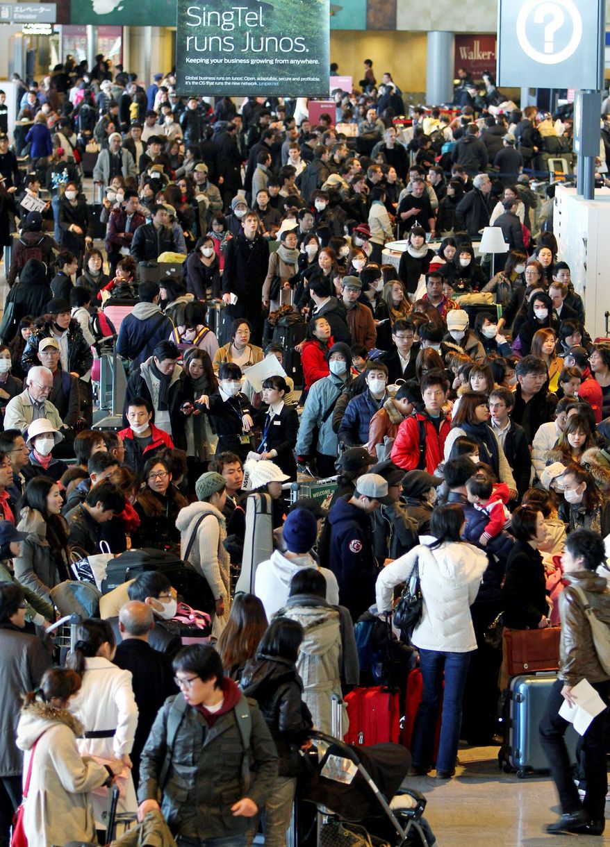 GETTING OUT: People hoping for a flight out wait in long lines at the check-in counters at Narita International Airport near Tokyo on Thursday. Many companies urged their workers to leave the capital. The U.S. government also authorized evacuations of American citizens out of the country. (Bloomberg)