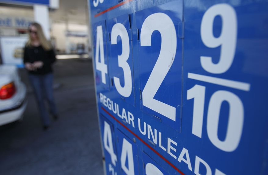 ** FILE ** In this file photo taken March 9, 2011, a woman returns to her car after filling up at a gas station advertising regular gasoline on sale for $4.32 in San Diego. Americans paid more for food and energy in February, but outside those volatile categories inflation was tame. (AP Photo/Gregory Bull, file)