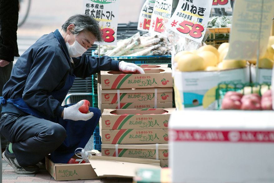 A worker stocks tomatoes from Tochigi prefecture at a market Sunday in Tokyo. Japan announced the first signs that contamination from its tsunami-crippled nuclear complex have seeped into the food chain. (Associated Press)
