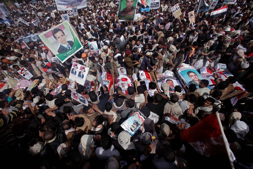 Anti-government protestors gather by the bodies of demonstrators during their funeral procession in Sanaa on Sunday. The men were killed during clashes Friday with Yemeni security forces. (Associated Press)