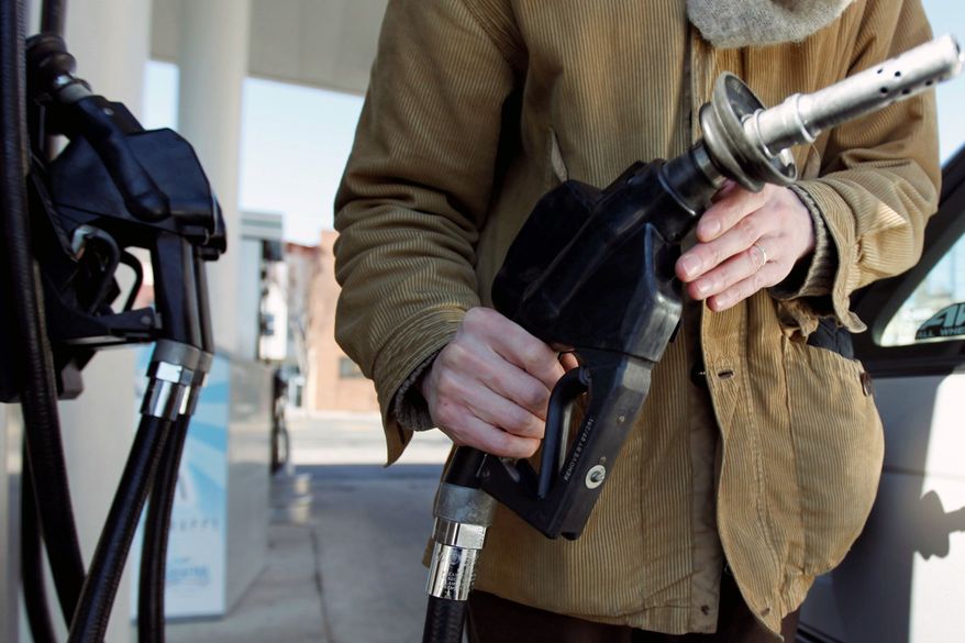 A motorist in Philadelphia returns the nozzle to the pump after filling up recently. Oil prices rose above $104 per barrel Tuesday as traders continue to focus on international crises driving supply and demand. (Associated Press)