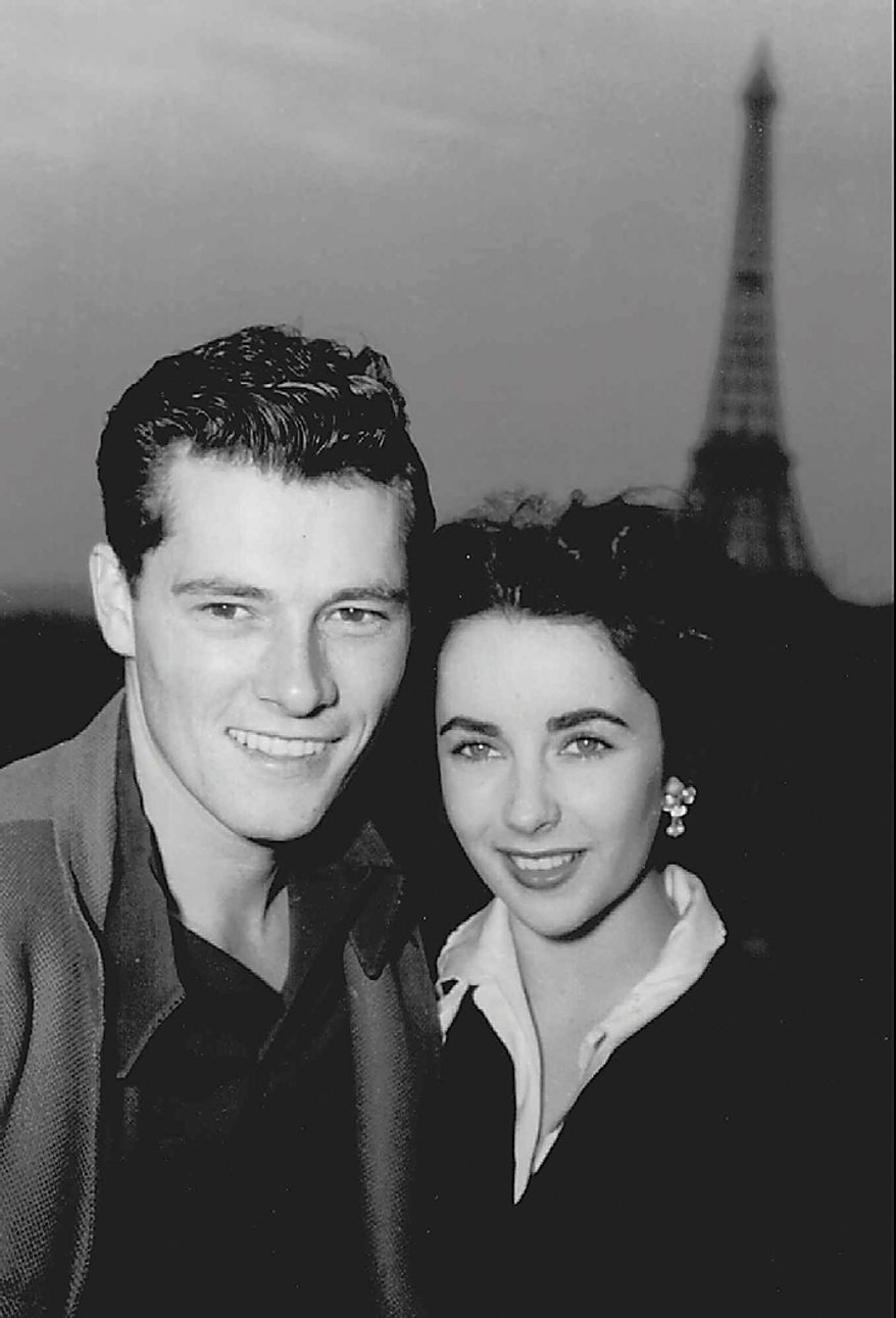 In this May 31, 1950 file photo, actress Elizabeth Taylor poses with her new husband, hotel heir Nick Hilton, as they stand on the terrace of their hotel room in Paris while on their honeymoon. Publicist Sally Morrison says Taylor died Wednesday, March 23, 2011 in Los Angeles of congestive heart failure at age 79. (AP Photo/File)