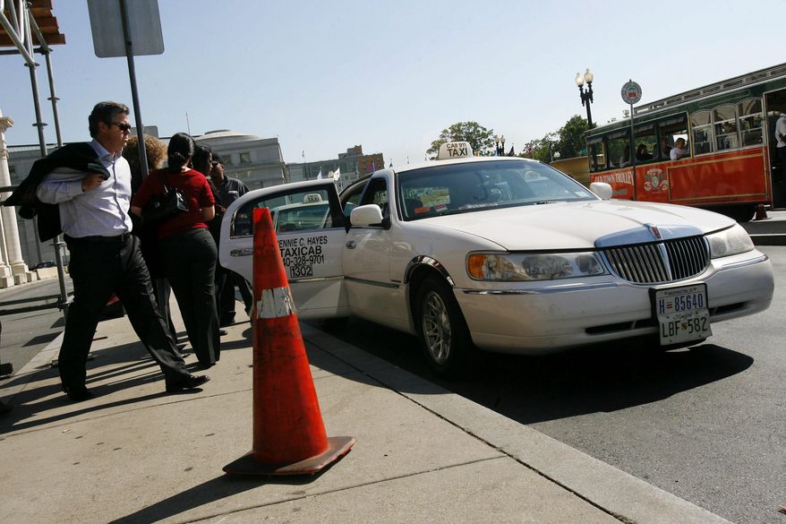 ** FILE ** A taxi driver picks up passengers outside Union Station in Washington. Beginning Monday, March 28, 2011, taxis will charge an extra $1 a ride to offset higher gas prices. (AP Photo/Jacquelyn Martin, File)
