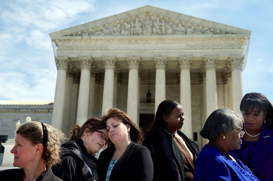 Stephanie Odle, of Norman, Okla., hugs daughter Sydney, 14, on the steps of the Supreme Court on Tuesday as the nation's high court hears arguments as to whether plaintiffs will be allowed to bring a class-action discrimination suit against Wal-Mart, the nation's largest retailer. (Rod Lamkey Jr./The Washington Times)