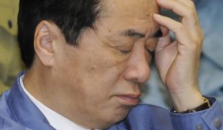 **FILE** Japanese Prime Minister Naoto Kan, wearing one of the blue work jackets that have become ubiquitous among bureaucrats since the tsunami, reacts during a budget committee meeting in parliament&#39;s upper house in Tokyo on March 29, 2011. (Associated Press)