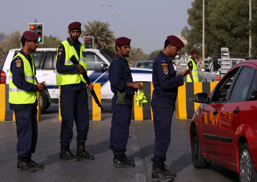 In this photo taken during a visit organized by Bahrain's Interior Ministry Bahrain police check a driver's identification at a checkpoint in the capital of Manama, Bahrain Monday, March 28, 2011. (AP Photo/Hasan Jamali)