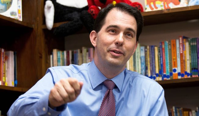 **FILE** Republican Wisconsin Gov. Scott Walker answers news media questions March 31 after a circuit judge forced him to halt implementing a law that cripples collective bargaining. (Associated Press)
