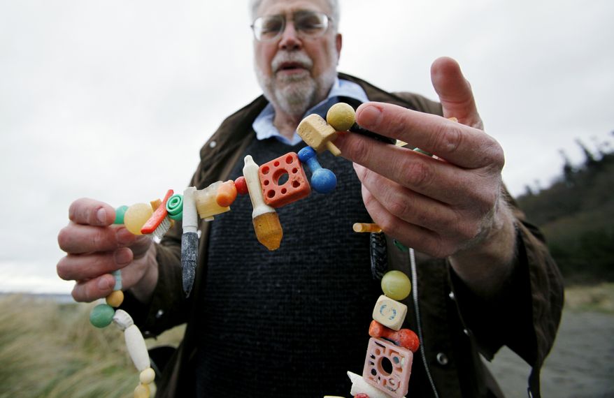Oceanographer Curt Ebbesmeyer displays a necklace made of ocean flotsam on Wednesday, March 30, 2011, in Seattle. Ebbesmeyer, who has traced Nike sneakers, rubber bath toys and hockey gloves spilled from Asian shipping containers over the decades, expects the first items of flotsam from Japan's tsunamis and earthquake to hit West Coast beaches in a year. (AP Photo/Elaine Thompson)