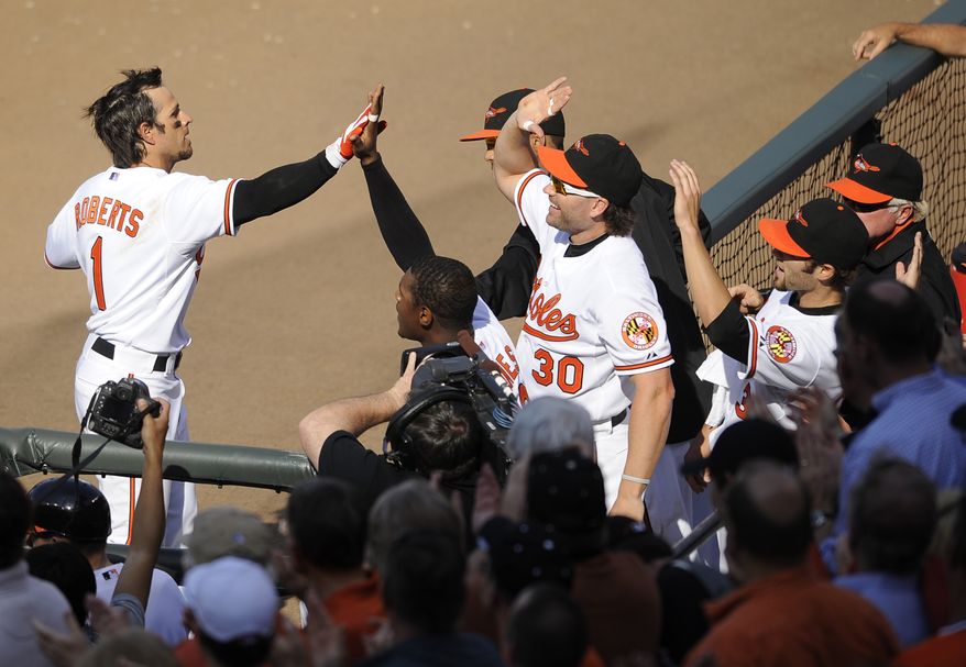 Baltimore Orioles' Brian Roberts (1) celebrates his three-run home run during the fifth inning of a baseball game against the Detroit Tigers, Monday, April 4, 2011, in Baltimore. Also seen is Baltimore's Luke Scott (30) .(AP Photo/Nick Wass)