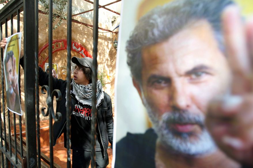 About 200 Palestinians and foreign activists gathered next to a large picture of slain actor and director Juliano Mer-Khamis flanked by a Palestinian flag and black flag of mourning. "I promise you to catch whomever did this very soon," his business partner Zakariya Zubeidi told the somber gathering. (Associated Press)