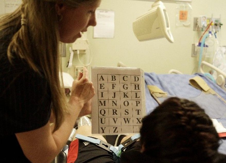Speech pathologist Kristi Lanier uses an alphabet card to interpret words for patient Itzel Garcia at the TIRR rehabilitation facility in Houston. Rep. Gabrielle Giffords has been undergoing rehabilitation at the clinic. (Associated Press)