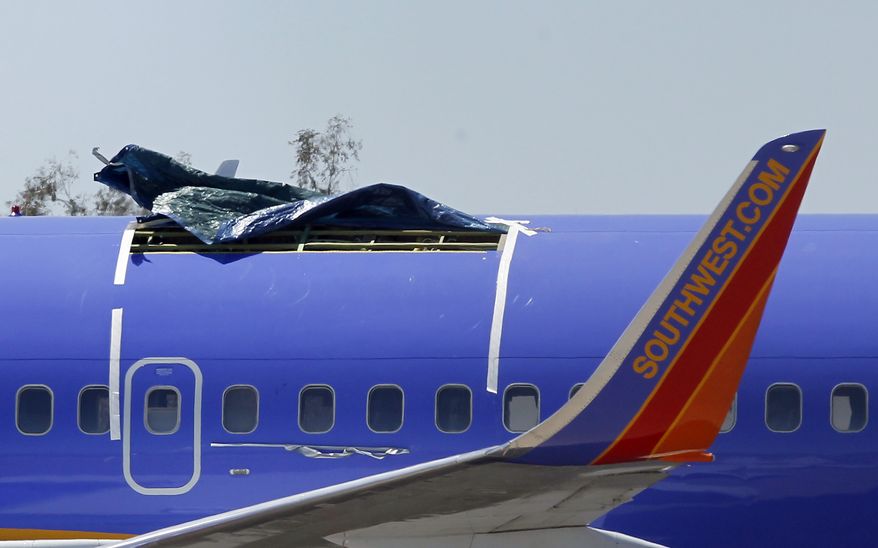A Southwest Airlines Boeing 737-300 sits in a remote area of the Yuma International Airport in Yuma, Ariz., on Monday, April 4, 2011, after a 5-foot-long tear in the aircraft's fuselage forced an emergency landing at the airport Friday. (AP Photo/Ross D. Franklin)