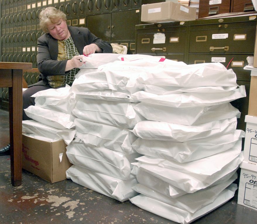 Donna Deuster, assistant city clerk, verifies security tags on sealed bags of 15,600 ballots cast in Racine, Wis. The ballots may have to be recounted in the wake of the narrow margin of victory in the state Supreme Court race. (Associated Press)