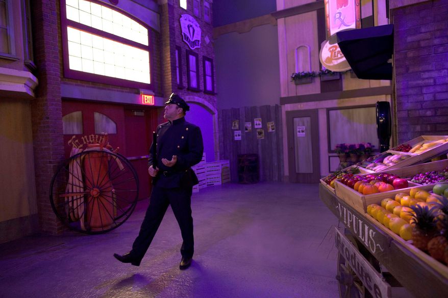An actor playing a beat cop walks through a set at the exhibit. (Associated Press)
