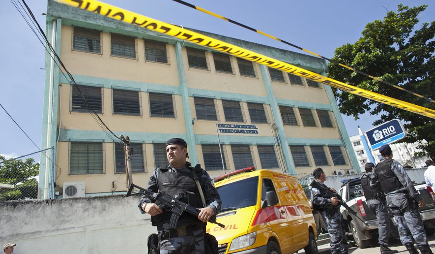 Police guard the perimeter of a school after a shooting in Rio de Janeiro, Brazil, Thursday April 7, 2011. Brazilian authorities say that a gunman opened fire in the elementary school and at least 13 people are dead, including the gunman. (AP Photo/Victor R. Caivano)