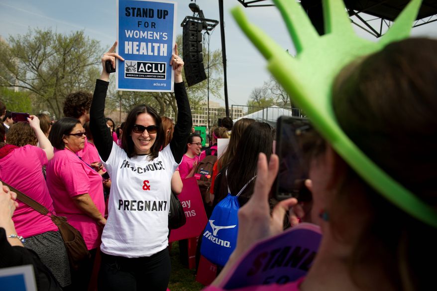 Sondra Goldschein (left) poses Thursday for friend Joanna Diamond (right) as they join in a Stand Up for Women's Health rally on the Mall. The event was sponsored by Planned Parenthood, NARAL Pro-Choice America, and other groups. (Rod Lamkey Jr./The Washington Times)
