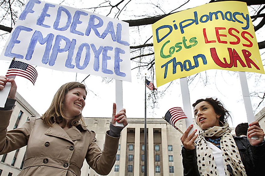 Susanne Brands, 22, left, and Mina Seljogi, 21, both interns at the American Foreign Service Association, attend a rally of U.S. diplomats and federal workers against the prospect of a government shutdown, Friday, April 8, 2011, in Washington. (AP Photo/Jacquelyn Martin)