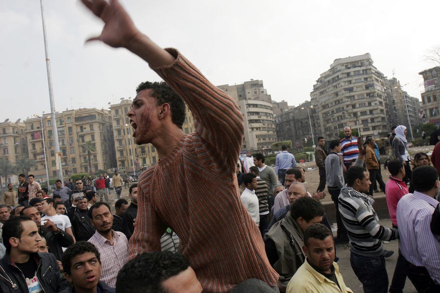 A protester chants slogans while riding on another man's shoulders following an attack by security forces in Tahrir Square, in Cairo, Egypt, Saturday, April 9, 2011. Soldiers beat hundreds of protesters with clubs and fired heavy volleys of gunfire into the air as part of a pre-dawn attack to clear away an overnight demonstration in Cairo's central Tahrir Square, in the latest sign of tensions between Egypt's ruling military and the country's protest movement. (AP Photo/Mohammed Abu Zaid)