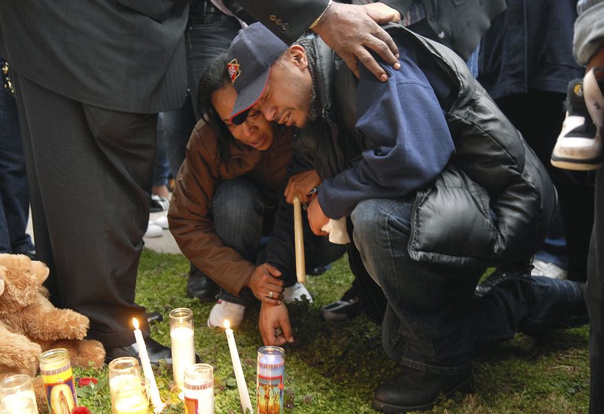 Israel Laboy, father of Robel Laboy, who was shot and killed Friday night at a teen party, is comforted by family members at candlelight vigil in Chester, Pa., on Saturday, April 9, 2011. Authorities say shots rang out Friday night at a social hall where the party was being held, killing two people and sending eight others to hospitals. (AP Photo/Delaware County Daily Times, Eric Hartline)