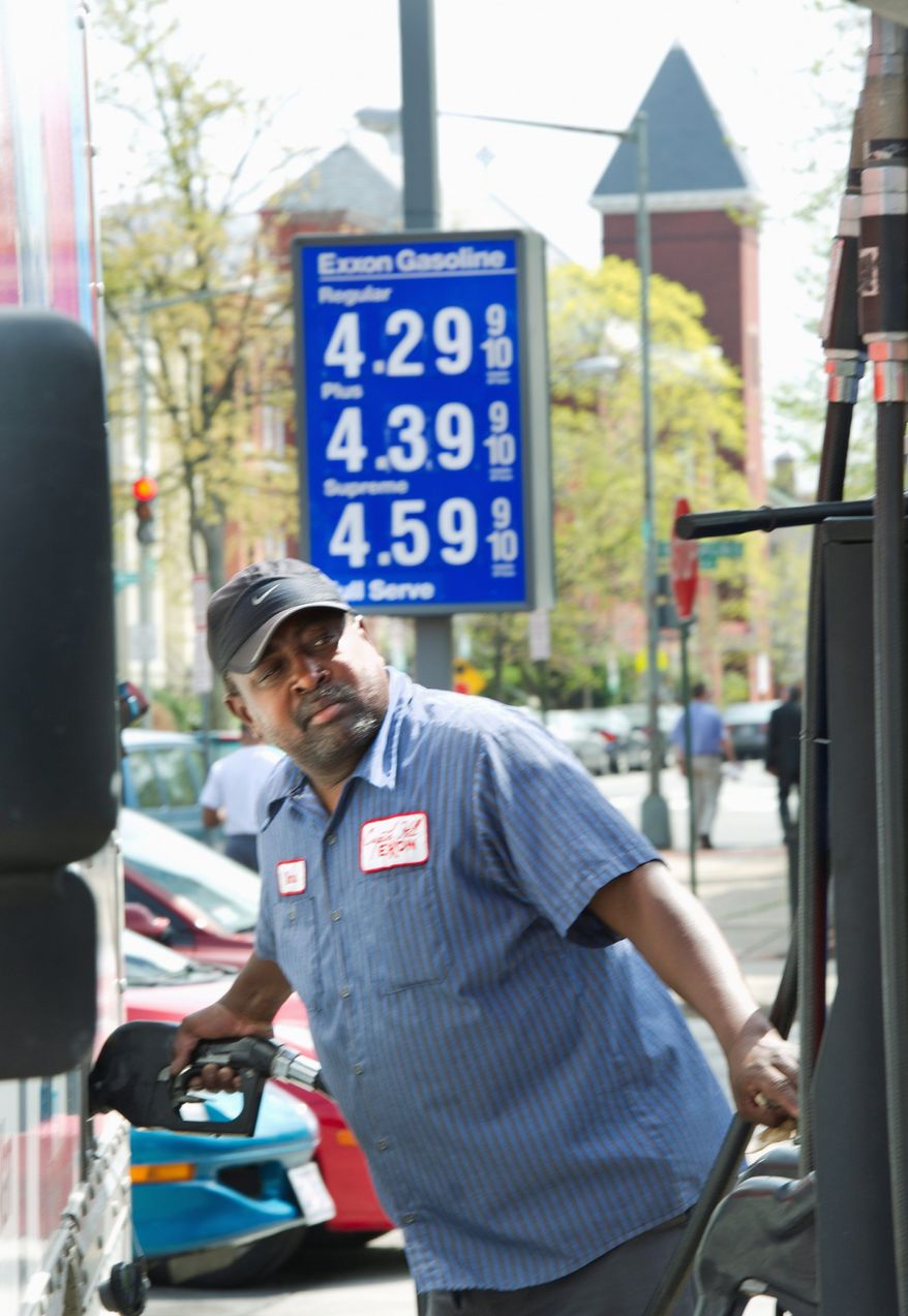 Dane Ellis, a full-service attendant at the Exxon station at the corner of 4th Street and Pennsylvania Avenue in Southeast, pumps gas into a truck on Monday. Station manager David "Woody" Woodall said that sales volume hasn't dropped off. "We have a lot of regular customers that just need their gas, so they're going to come here every day anyway," he said. (Barbara L. Salisbury/The Washington Times)