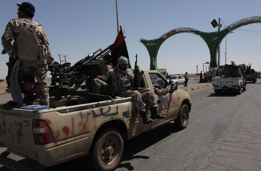 Reinforcements of Libyan rebel fighters move toward the front line as they pass through the western gate of the recaptured city of Ajdabiya, Libya, on Monday, April 11, 2011. The Libyan rebel council rejected a cease-fire proposal presented by an African Union delegation because it did not provide for the departure of Col. Moammar Gadhafi, the Libyan leader, and his top associates. (AP Photo/Nasser Nasser)