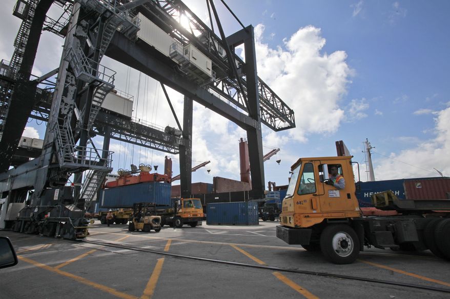 Large cranes load shipping containers onto trucks at the Port of Miami on Feb. 4, 2011, in Miami. U.S. companies sold fewer products overseas in February, but the trade deficit still narrowed because of a big decline in oil imports. (AP Photo/Wilfredo Lee)