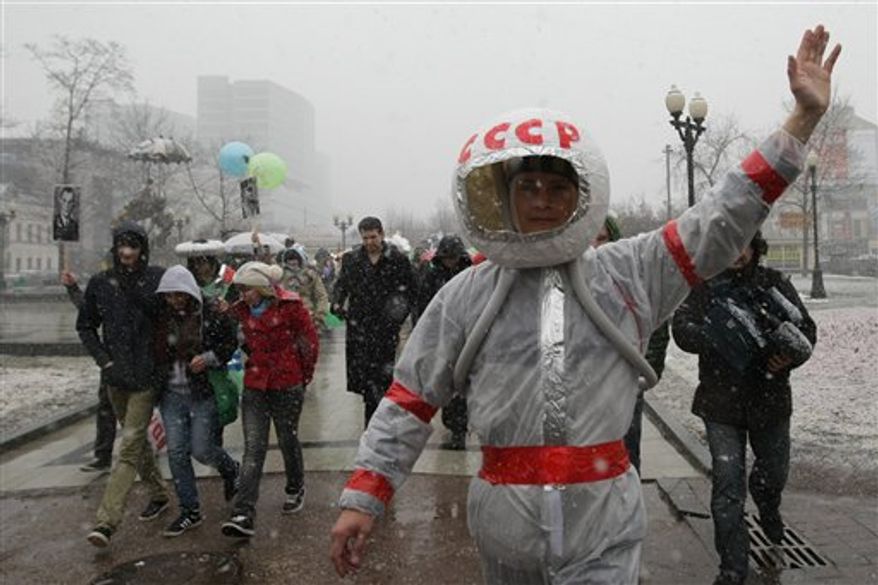 People participate in a flashmob rally to mark the 50th anniversary of Yuri Gagarin's mission, the first human spaceflight, in downtown Moscow, Tuesday, April 12, 2011. The letters on helmet are acronym for the USSR, Union of the Soviet Socialist Republics. (AP Photo/Sergey Savostyanov)