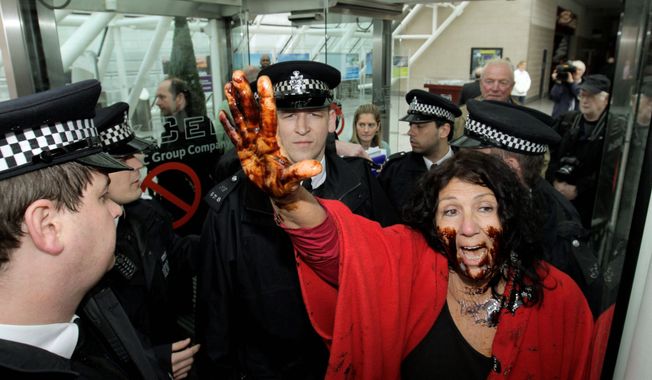 Diane Wilson, a fourth-generation Texas fisherwoman, her face smeared with syrup to represent oil, protests against BP as British police officers prevent her from entering the London conference center where the petroleum giant held the annual general meeting of its shareholders Thursday. &quot;I think a lot of the shrimpers are concerned,&quot; she said. (Associated Press)