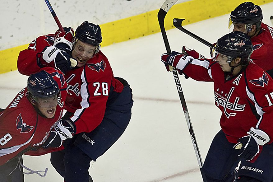 Teammates mob Capitals forward Alex Ovechkin after he scored a goal to tie the game at 1-1 during the third period of a playoff match against the New York Rangers at the Verizon Center in Washington on Wednesday, April 13, 2011. (Drew Angerer/The Washington Times)