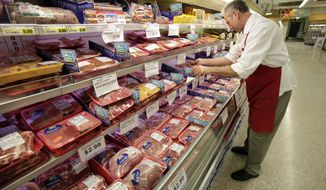 Meat department manager Kevin Morlan arranges packages of pork at a Dahl&#39;s grocery store in Des Moines, Iowa, on March 3, 2011. (AP Photo/Charlie Neibergall)