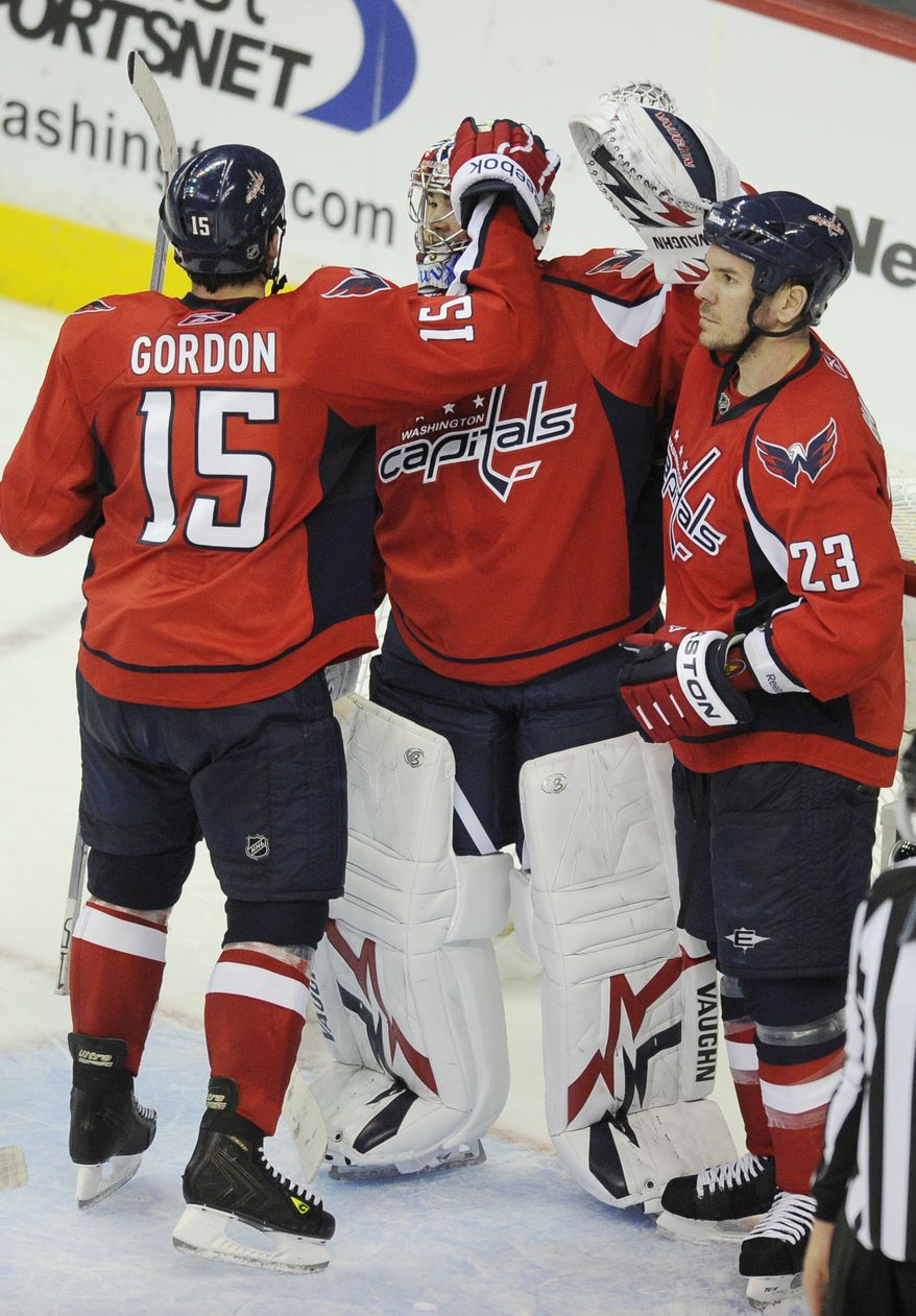 Washington Capitals right wing Boyd Gordon (15) celebrates teammates with Michal Neuvirth, center, of the Czech Republic, and Scott Hannan (23) after a 2-0 win over the New York Rangers in Game 2 of a first-round NHL Stanley Cup hockey playoff series on Friday, April 15, 2011, in Washington. (AP Photo/Nick Wass)
