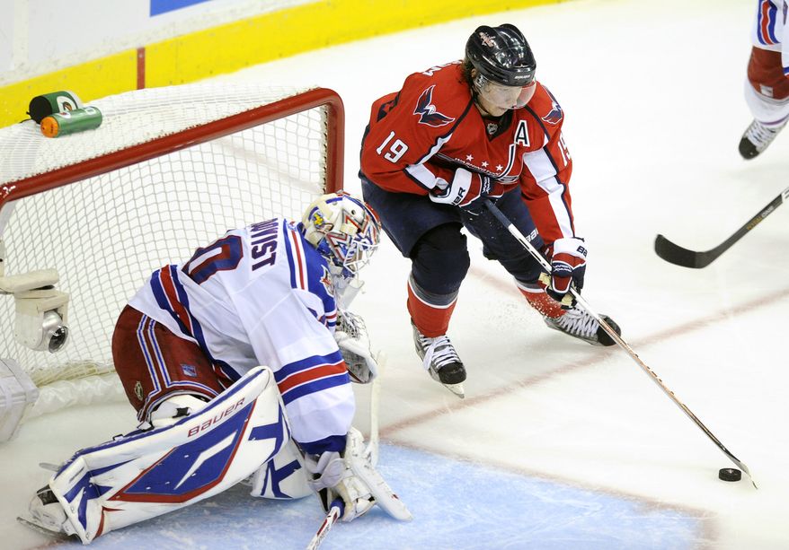 Washington Capitals center Nicklas Backstrom (19), of Sweden, brings the puck in front of New York Rangers goalie Henrik Lundqvist, left, also of Sweden, during the third period in Game 2 of a first-round NHL Stanley Cup hockey playoff series on Friday, April 15, 2011, in Washington. (AP Photo/Nick Wass)