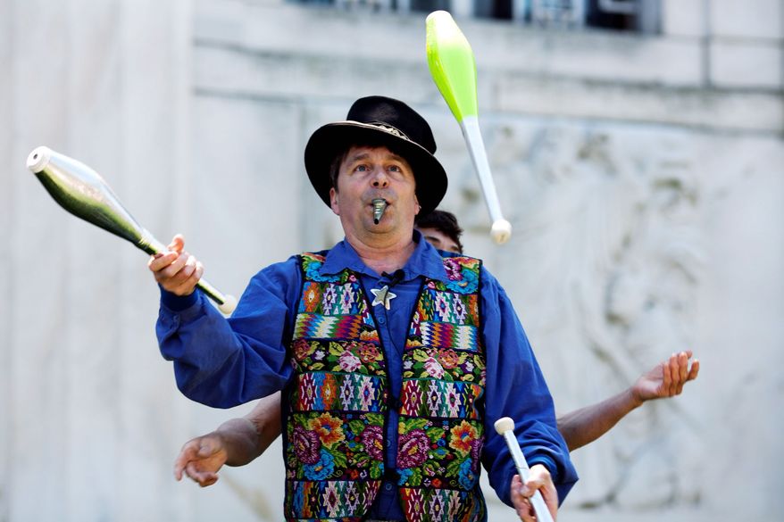 Jester and entertainer Nick Newlin juggles for visitors at Shakespeare's birthday celebration. (Drew Angerer/The Washington Times)