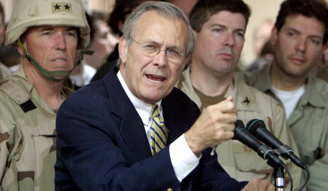 ** FILE ** Former Defense Secretary Donald H. Rumsfeld, here in 2004 with U.S. troops in Iraq. (Associated Press)