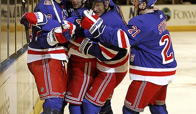 New York Rangers center Brian Boyle (left), left wing Wojtek Wolski (second from right) and center Derek Stepan (21) celebrate with center Erik Christensen (second from left) after Christensen scored against the Washington Capitals in the second period of Game 3 of a first-round NHL Stanley Cup playoff series at Madison Square Garden in New York, Sunday, April 17, 2011. (AP Photo/Kathy Willens)
